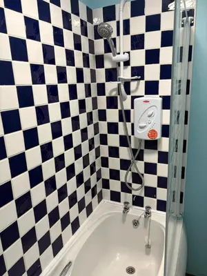 a bathroom with a shower and a bath tub at Maryport town centre cosy home in Maryport