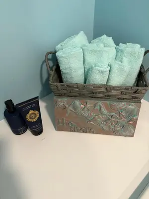a basket of towels on a counter with a bottle of soap at Maryport town centre cosy home in Maryport