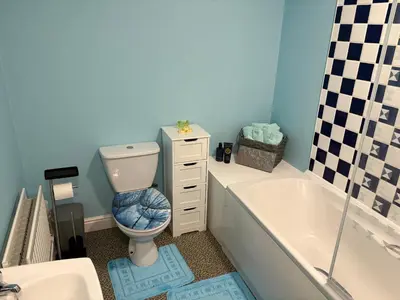 a bathroom with a toilet and a tub and a sink at Maryport town centre cosy home in Maryport