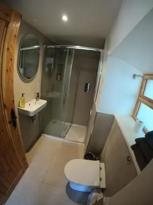 a bathroom with a shower and a toilet and a sink at Holly Lodge, Gilchristland Organic Farm cottage in Closeburn