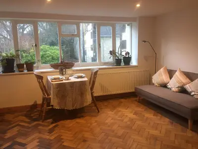 a living room with a table and a couch at Holly Lodge, Gilchristland Organic Farm cottage in Closeburn