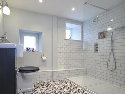 a white bathroom with a shower and a toilet at 5 Bed in Cockermouth oc-sz424 in Lorton