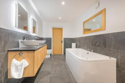 a bathroom with a tub and a sink and a toilet at Cozy Lake District House on the fells in Ambleside