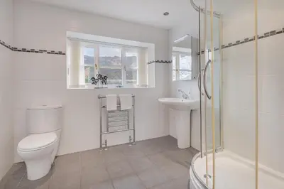 a bathroom with a toilet and a sink and a shower at Cozy Lake District House on the fells in Ambleside