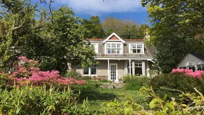 an old house with flowers in the yard at Elm Cottage in Kippford