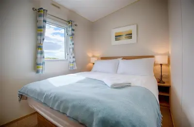 a bedroom with a large bed with a window at Konkers in Girthon