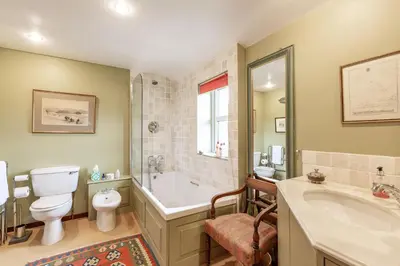 a bathroom with a tub and a toilet and a sink at Lochpatrick Mill in Castle Douglas