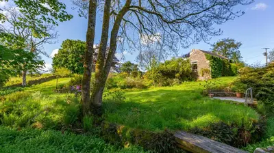 an old house in the middle of a green yard at Lochpatrick Mill in Castle Douglas