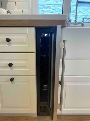 a black refrigerator in the middle of a kitchen at Modern cottage with hot tub in Kirkcudbright