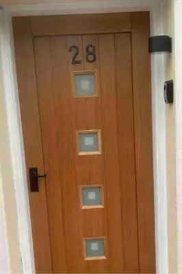 a wooden door with the number on it at Modern cottage with hot tub in Kirkcudbright