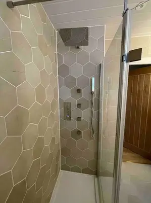 a shower with a glass door in a bathroom at Modern cottage with hot tub in Kirkcudbright