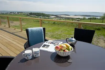 a table with a bowl of fruit on a balcony at Granary Lodge in Girthon