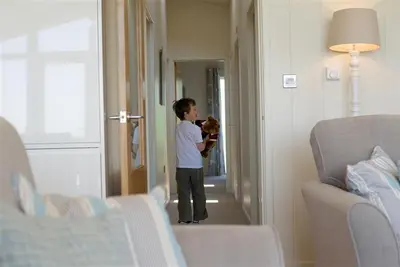 a young boy holding a teddy bear in a room at Granary Lodge in Girthon