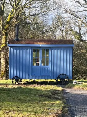 a blue shed sitting on the side of a road at Highland Hideaway in Wigton