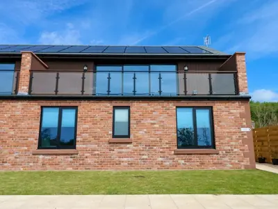 a house with solar panels on the roof at Silverbirch Cottage - 3 Bedrooms - Sleeps 6 in Frizington