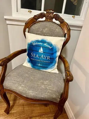 a pillow on a chair with a sea kayak on it at Sea Ayr - City Centre Apartment in Ayr