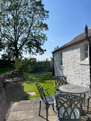 a table and chairs sitting outside of a building at Barcloy Milk House in Kirkcudbright