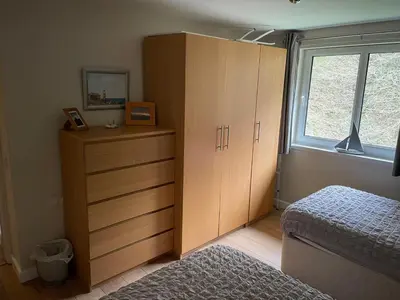 a bedroom with a bed and a dresser and a window at Portpatrick 2 bedroom Self Catering Flat in Portpatrick