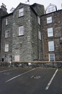 a large brick building with white windows on a street at Chaucer View, Chaucer House Apts in Keswick