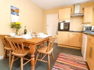 a kitchen with a wooden table and chairs in a room at Maiden Moor in Keswick