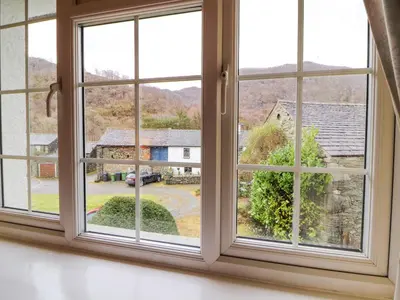 an open window with a view of a house at Maiden Moor in Keswick