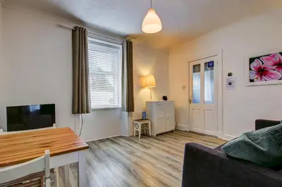 a living room with a couch and a television at Apartment Caerlaverock Road in Prestwick