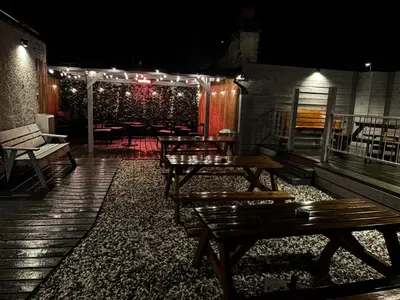 a patio with wooden benches and tables with lights at The Cassillis Hotel - Smart Self Check-in Hotel & Bar in Maybole