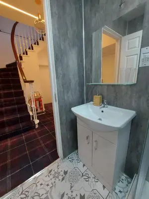 a bathroom with a sink and a staircase at The Cassillis Hotel - Smart Self Check-in Hotel & Bar in Maybole
