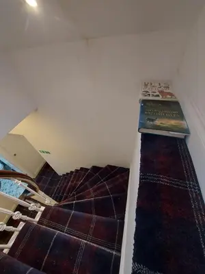 a attic room with a bed with a rug at The Cassillis Hotel - Smart Self Check-in Hotel & Bar in Maybole