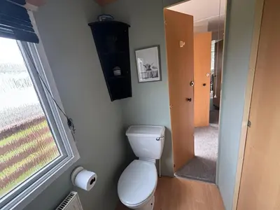 a small bathroom with a toilet and a window at No 38 Heilan Hoose at Three Lochs Newton Stewart in Newton Stewart