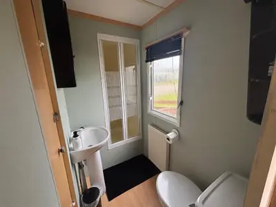 a bathroom with a sink and a toilet and a window at No 38 Heilan Hoose at Three Lochs Newton Stewart in Newton Stewart