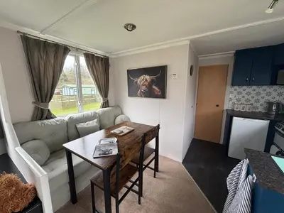 a living room with a couch and a table at No 38 Heilan Hoose at Three Lochs Newton Stewart in Newton Stewart