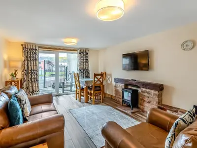 a living room with a couch and a fireplace at Turnip House - Uk48909 in Allonby