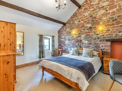 a bedroom with a brick wall and a bed at Barley Store - Uk48910 in Allonby
