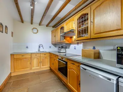 a kitchen with wooden cabinets and white appliances at Barley Store - Uk48910 in Allonby