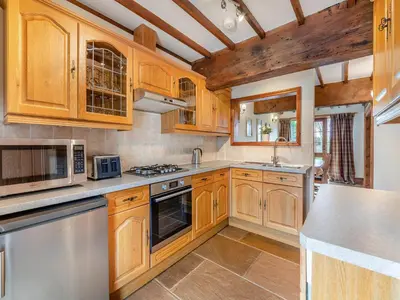 a kitchen with wooden cabinets and stainless steel appliances at Engine House - Uk48912 in Allonby