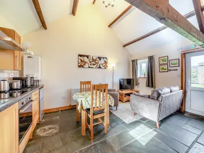 a kitchen and living room with a table and chairs at Eight Byre - Uk48913 in Allonby