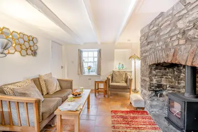 a living room with a stone fireplace and a couch at 2 Bed in Kirkcudbright oc-a30803 in Kirkcudbright