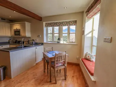a kitchen with a table and chairs in a room at Squirrel Cottage in Keswick