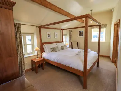 a bedroom with a canopy bed in a room at Squirrel Cottage in Keswick