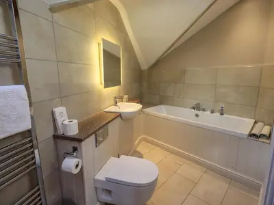 a bathroom with a toilet and a sink and a tub at Squirrel Cottage in Keswick