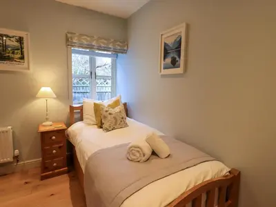 a bedroom with two twin beds and a window at Fox Howe in Keswick