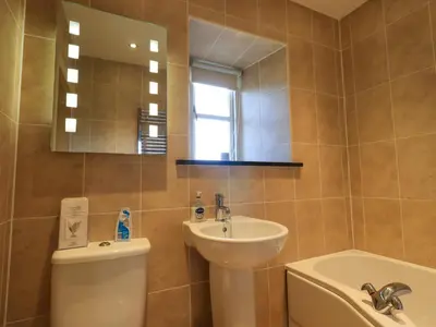 a bathroom with a sink and a toilet and a mirror at Fox Howe in Keswick