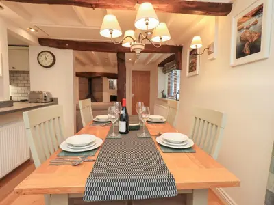 a dining room with a table with plates and wine glasses at Jasmine Cottage in Keswick