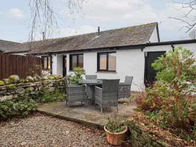 a house with a table and chairs in the backyard at Jasmine Cottage in Keswick