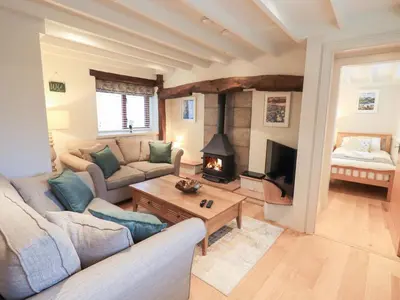 a living room with a couch and a fireplace at Jasmine Cottage in Keswick