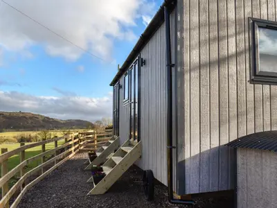 a building with a staircase leading to the side of it at Meadows View Shepherd's Hut in Cockermouth