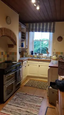 a kitchen with a stove and a sink and a window at Rose cottage on the peaceful solway coast in Port Carlisle
