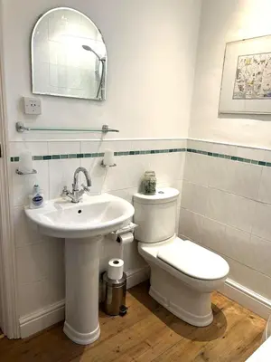 a white bathroom with a toilet and a sink at Rose cottage on the peaceful solway coast in Port Carlisle