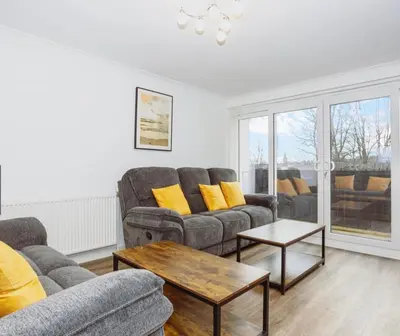 a living room with two couches and a table at Caul View Apartment in Dumfries